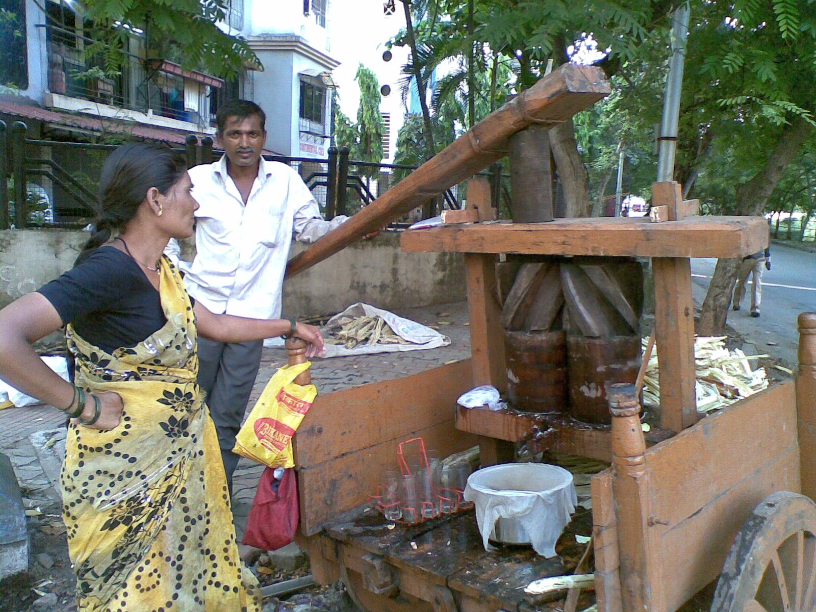 The couple who operates the wooden sugarcane juice machine